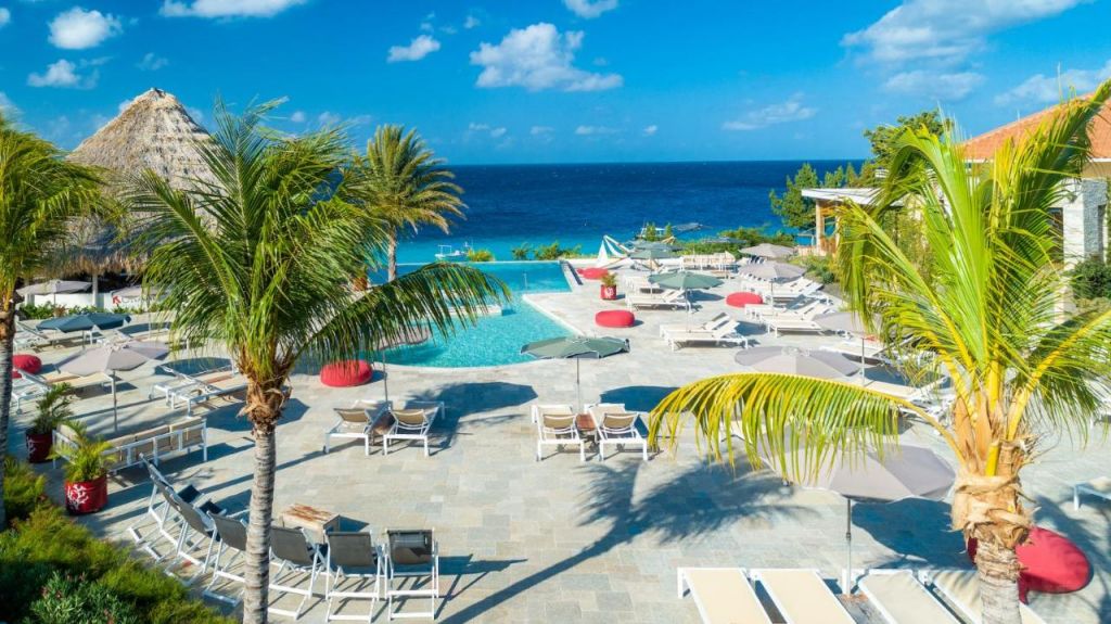 piscina de borda infinita com área de espreguiçadeiras em resorts em Curaçao