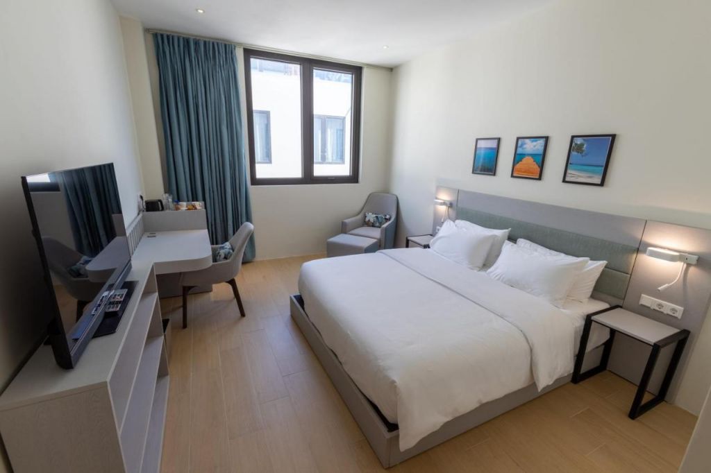 Suíte com cama de casal, poltrona, mesinha e televisão em hotéis em Curaçao