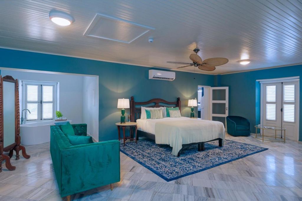Suíte em hotéis em Curaçao com banheira, ventilador de teto e sofá.