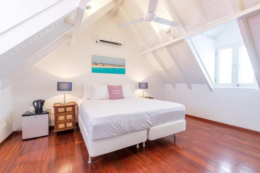 Suíte com cama extra grande, cafeteira, ventilador de teto e luz natural